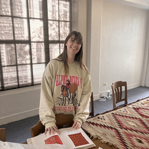 Kate with research materials and one of the Navajo rugs.