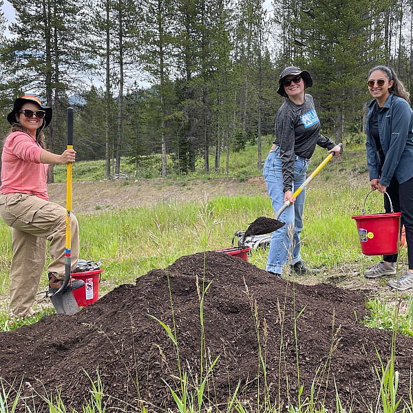 Gaby Garza ’22, Lupe Sanchez ’23, and Christine Vanginault ’23  spread compost on the research plots