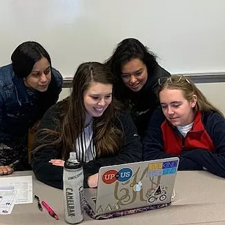 Southwestern University students gathered around computer